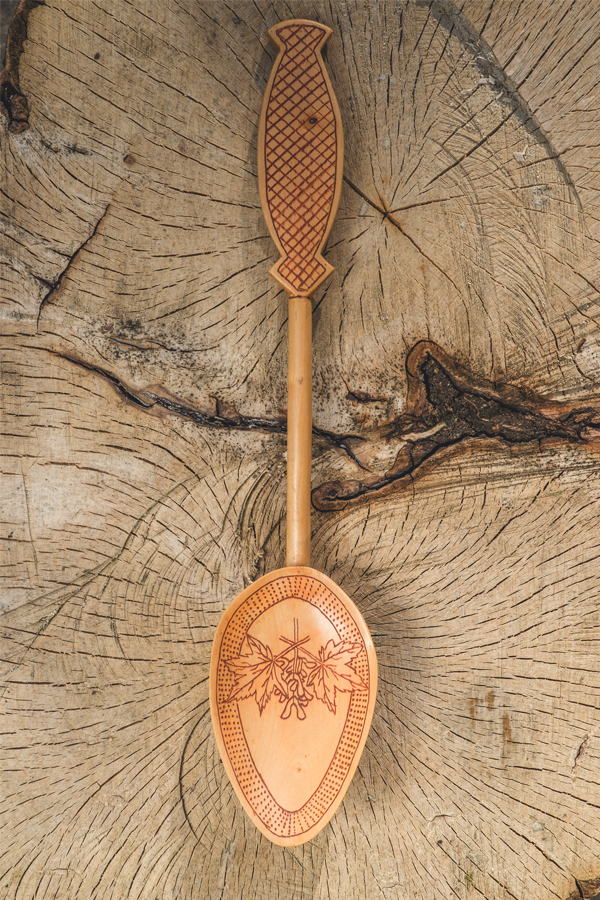A hand-carved spoon with burnt embellishments.