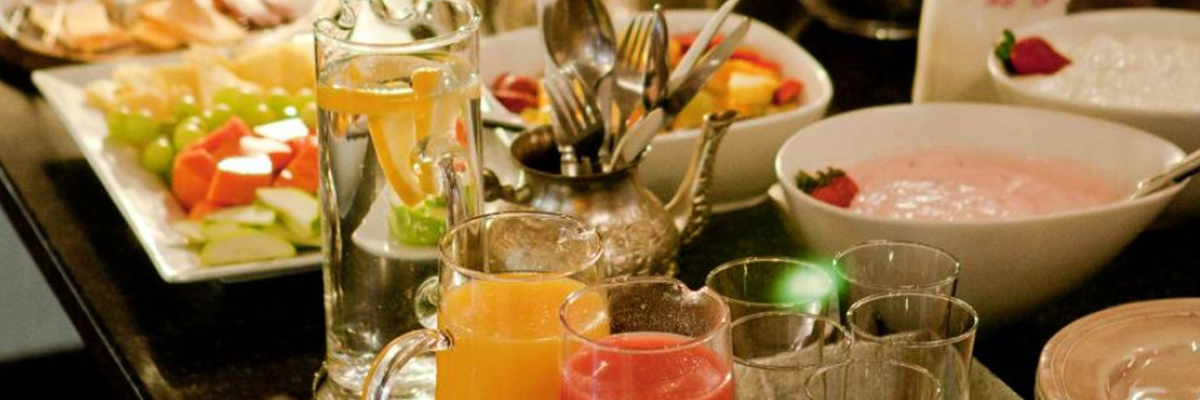 A beautiful selection of fresh fruits and pastries laid out for breakfast and fresh squeezed juices